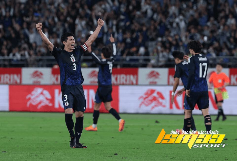 นักฟุตบอลทีมชาติญี่ปุ่นชูแขนดีใจหลังจบเกม ท่ามกลางแฟนบอลที่ส่งเสียงเชียร์ในสนาม โดยมีเพื่อนร่วมทีมร่วมฉลองชัยชนะ พร้อมโลโก้ “LSM99SPORT” ที่มุมล่างขวาของภาพ
